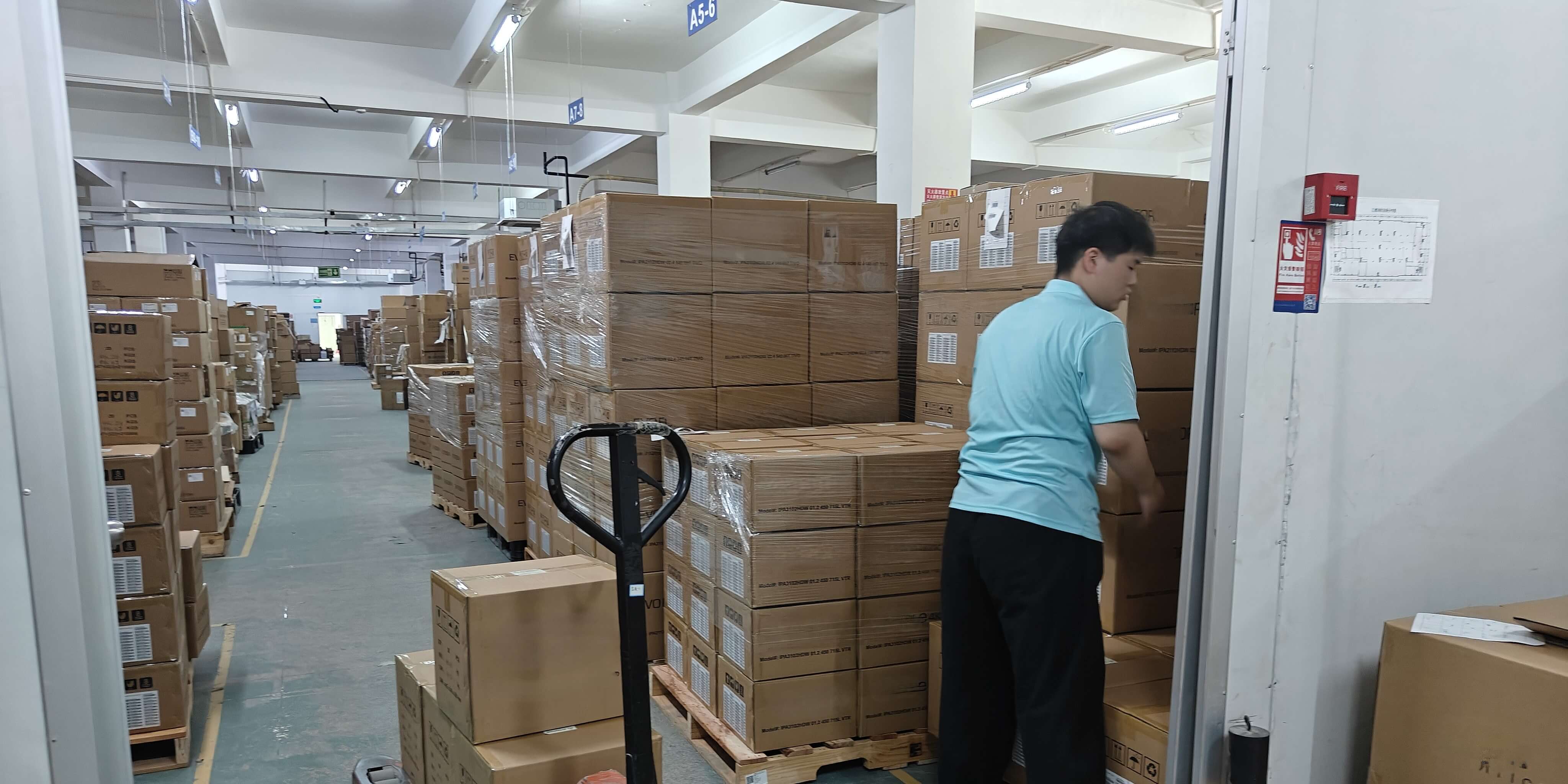 Worker loading packed goods in a logistics warehouse for PCB assembly export shipments